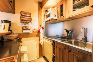 Kitchen equipped with a sink, microwave, and kettle.