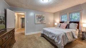 A bedroom with a bed, dresser, and artwork on the wall. - Dogs Give us 5 Stars! 3BR, Large Fenced Yard, Rustic Escape (Orange Park)