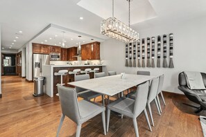 A modern kitchen with wooden cabinets, stainless steel appliances, and a central island. - Designer Mountain View Ritz-Carlton Home by InvitedHome | Ski Valet, Hot Tub (Vail)
