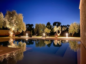 Una piscina al aire libre, tumbonas