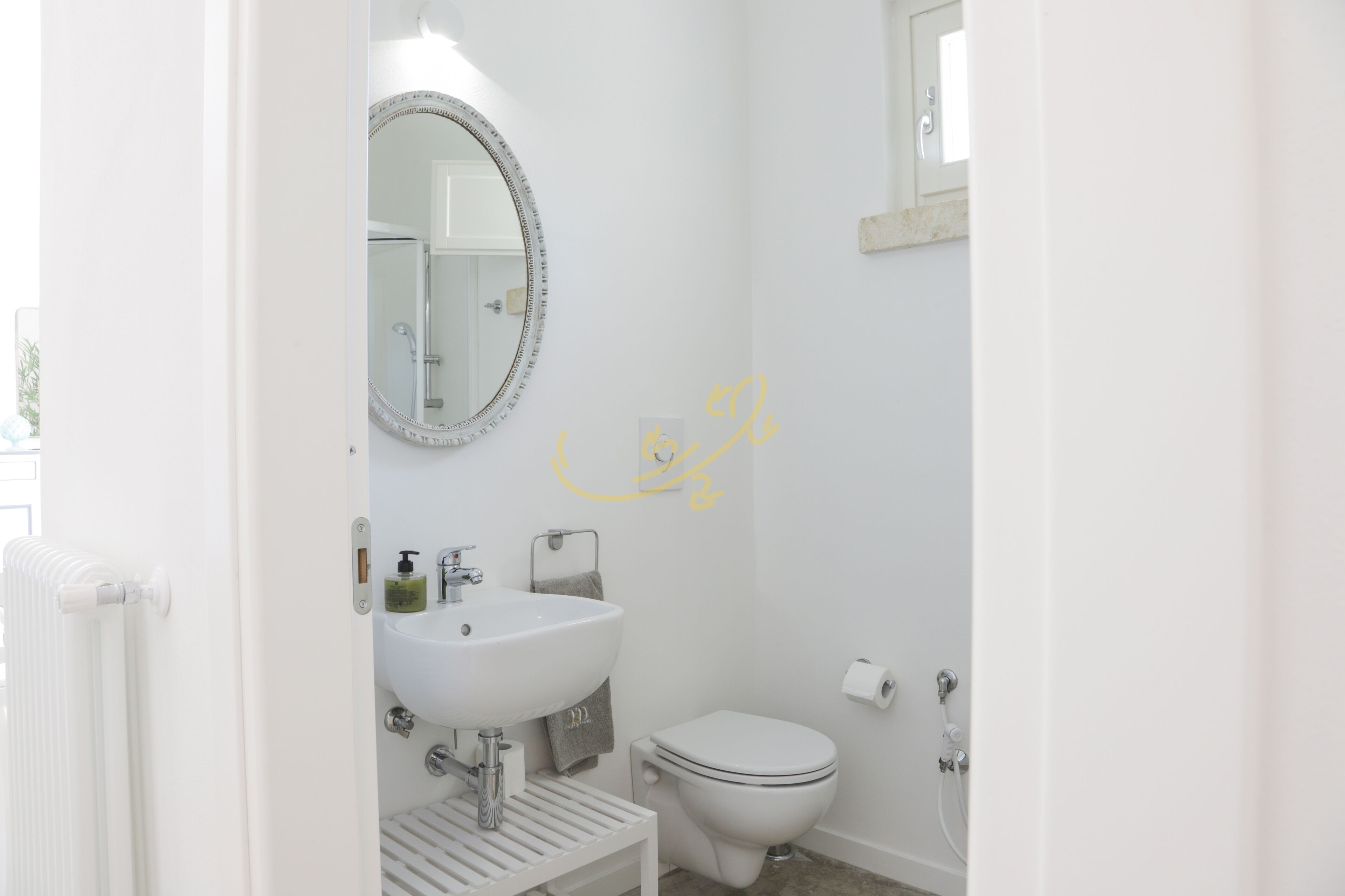 A bathroom with a white sink, a toilet, and a mirror.