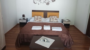 Habitación de hotel impecable con una cama grande, dos mesitas de noche y un adorno decorativo en la pared.