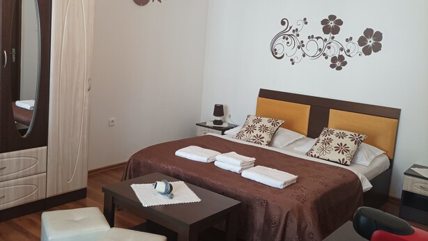 A well-lit bedroom with a bed, bedside table, and a wardrobe.