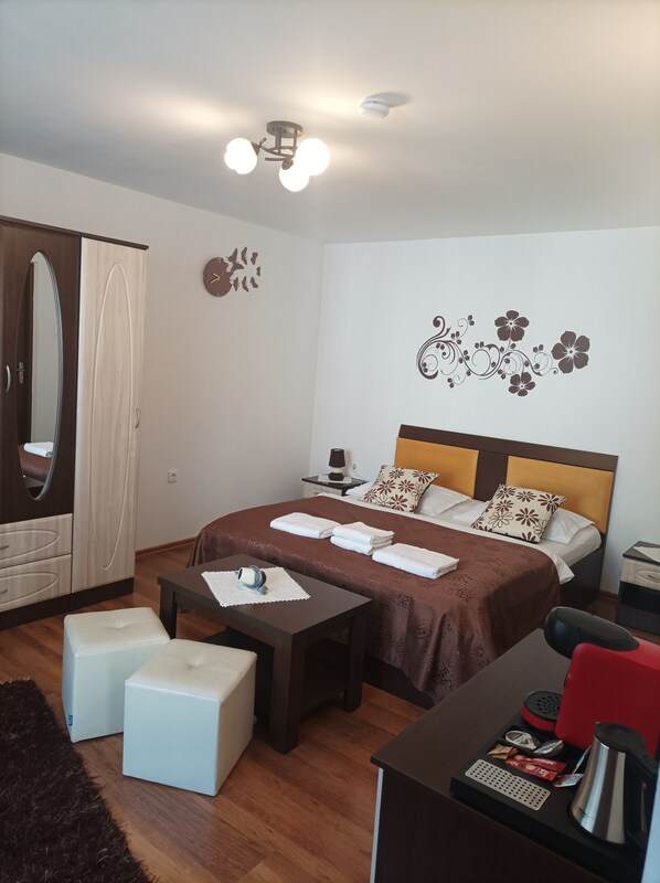 A well-lit bedroom with a bed, bedside table, and a wardrobe.