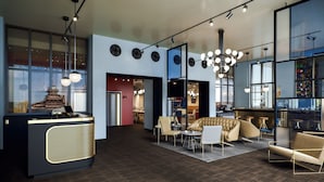 Un interior moderno con mostrador de recepción, zona de estar y bar.