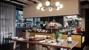 Una cocina moderna con una mesa de comedor de madera, taburetes de bar y una isla central con horno integrado.