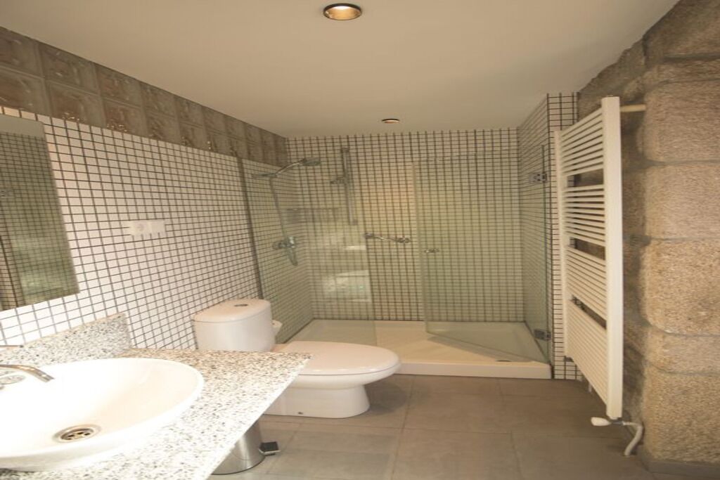 A bathroom with a sink, toilet, and glass-enclosed shower.