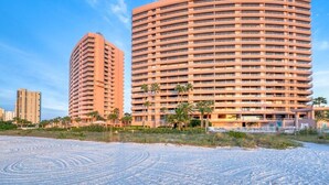 A large, circular hotel with multiple balconies and a beachside location. - Beachfront Sky High Views-14th Floor- Sand Key! Resort Level Amenities! (Clearwater)