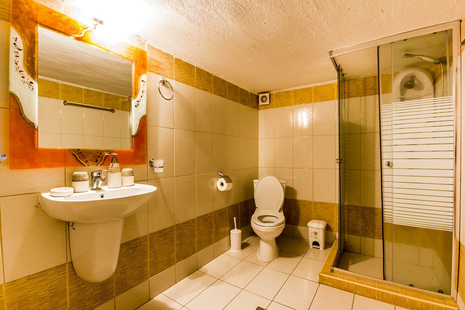 Un baño con lavamanos, inodoro y zona de ducha.