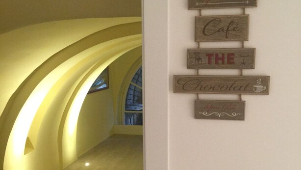 A hallway with a sign reading "Cafe The Chocolat" and a date "August 1932". - B&B Turin Très Chic. In the historic center with its own entrance (Torino)