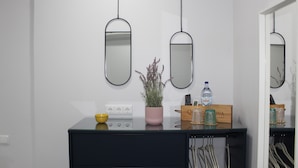 A modern kitchen with a black countertop, a yellow bowl, a pink plant, and a water bottle. - Bella Gaia (Vila Nova de Gaia)