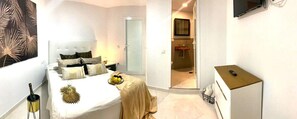 Relax in a serene space with a neatly made bed, bedside table, and large window offering a view.