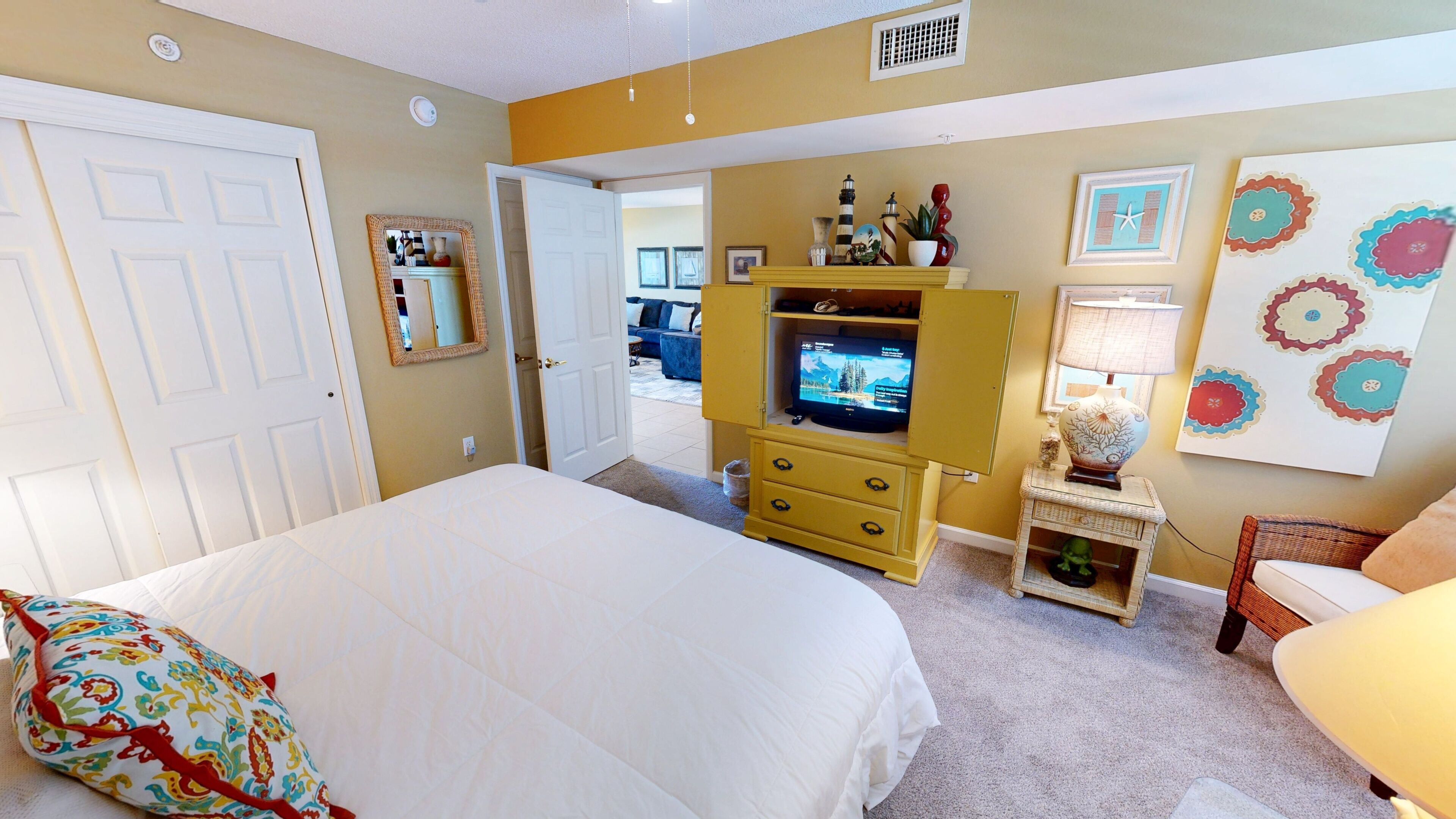 A bedroom with a bed, a television, a dresser, and a chair.