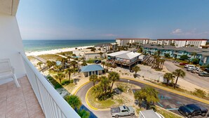 Un hôtel situé sur la côte, avec vue sur la plage, composé de plusieurs bâtiments et disposant d’un parking.
