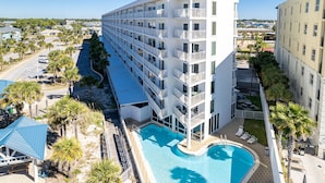 Un hôtel à plusieurs étages doté d’une piscine, de balcons et offrant une vue sur les environs.