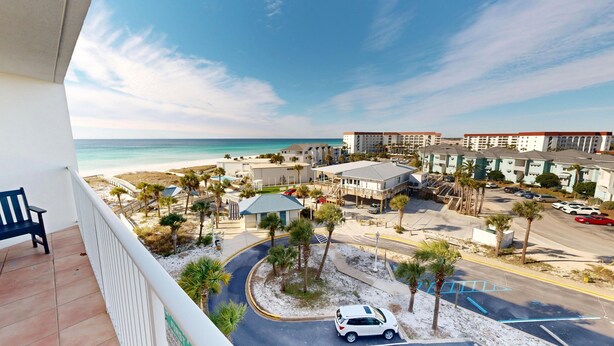Ein Hotel direkt am Strand mit Pool, Palmen und Meerblick.