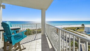 A balcony with a view of the beach, a chair, and a railing. - Seacrest 501AB is a Gulf Front 3 BR on Okaloosa Island by RedAwning (Fort Walton Beach)