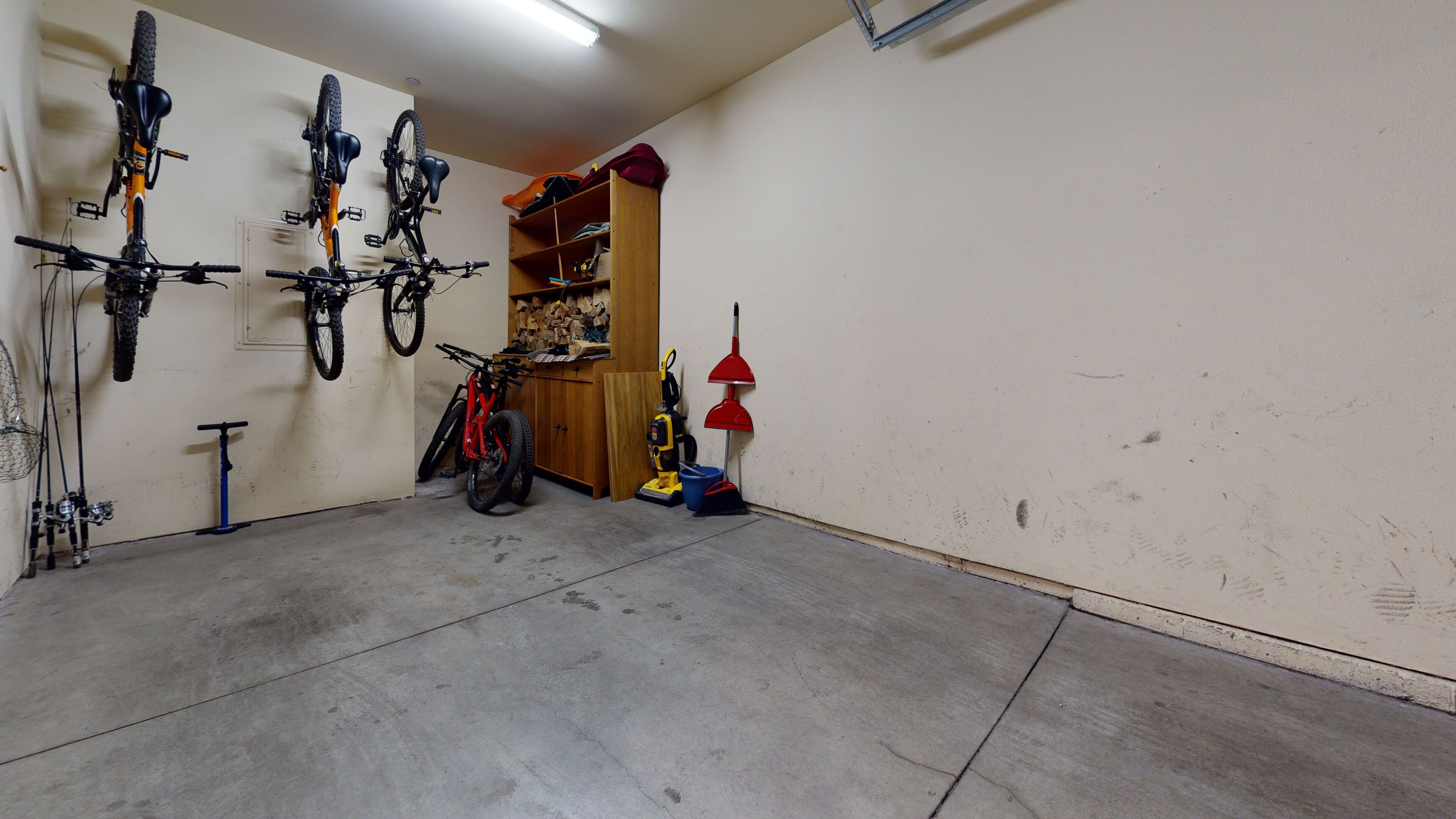 Un garage con biciclette, uno straccio e uno scooter.
