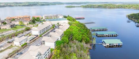 A lakeside hotel with multiple buildings, docked boats, and a clear view of the lake.