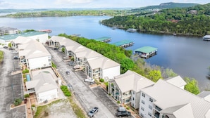 A waterfront hotel with multiple buildings, a parking lot, and docked boats.