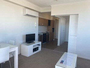 Cozy living space with a kitchenette, flat-screen TV, and dining area.
