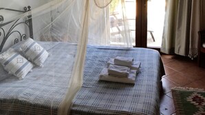 A bed with a canopy, pillows, and a folded towel on a checkered bedspread. - Fig Tree Villa, private pool & whirl pool, seclusion, privacy, spectacular views (Marmaris)