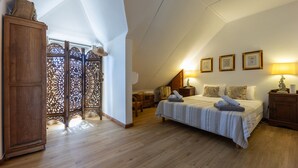 Una camera da letto con un letto grande, un'armadio in legno e un portafinestra decorativo.