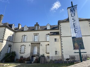 A building with a large banner reading "MUSEE" and a stone facade. - TUMULUS - Holiday home for rent in Carnac - S23 (Carnac)