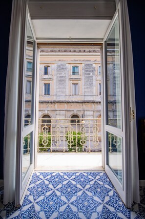 A view from a room with a patterned floor through a glass door leading to a balcony. - Crudo Home (Pompei)