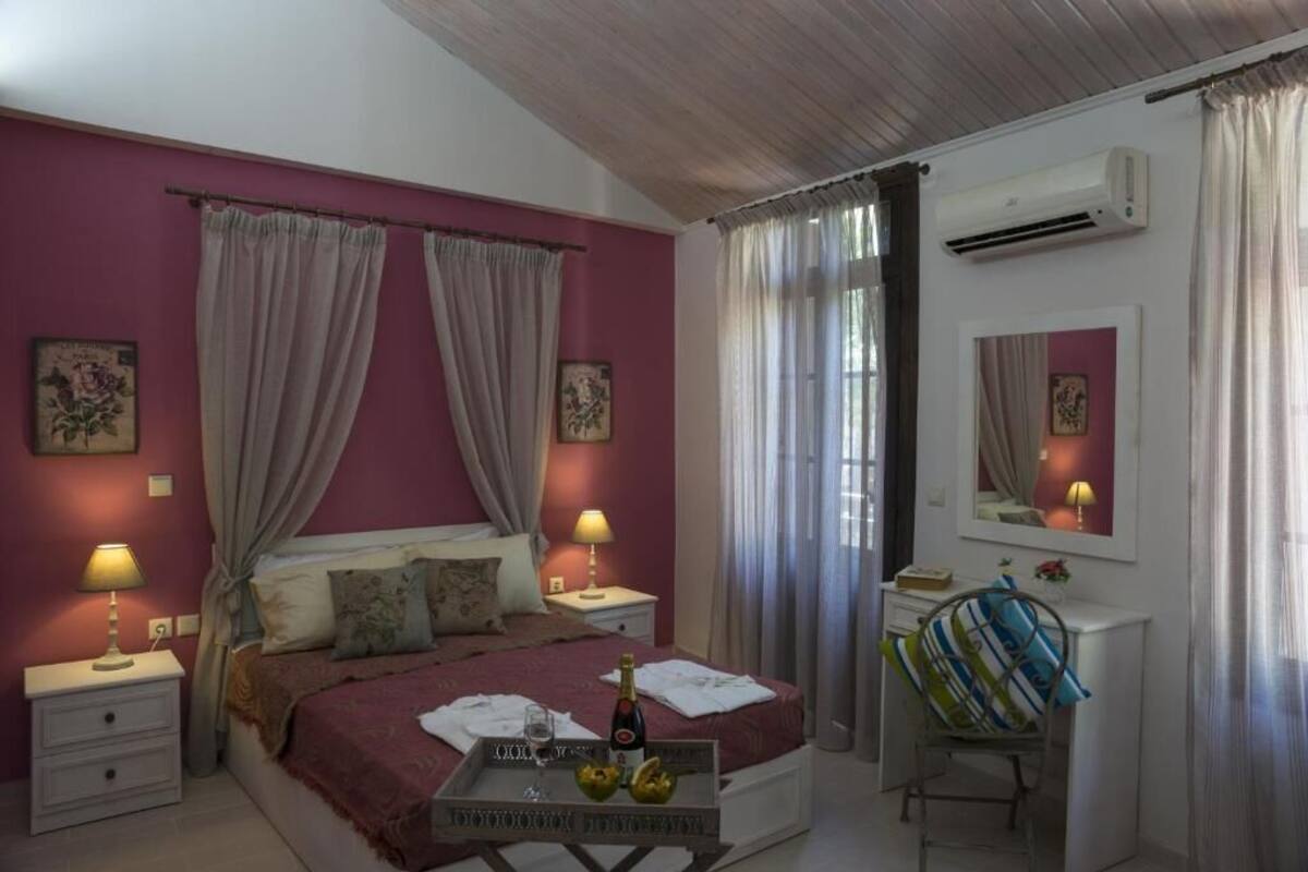 Een slaapkamer met een bed, nachtkastjes, een bureau, een stoel en een airconditioning.
