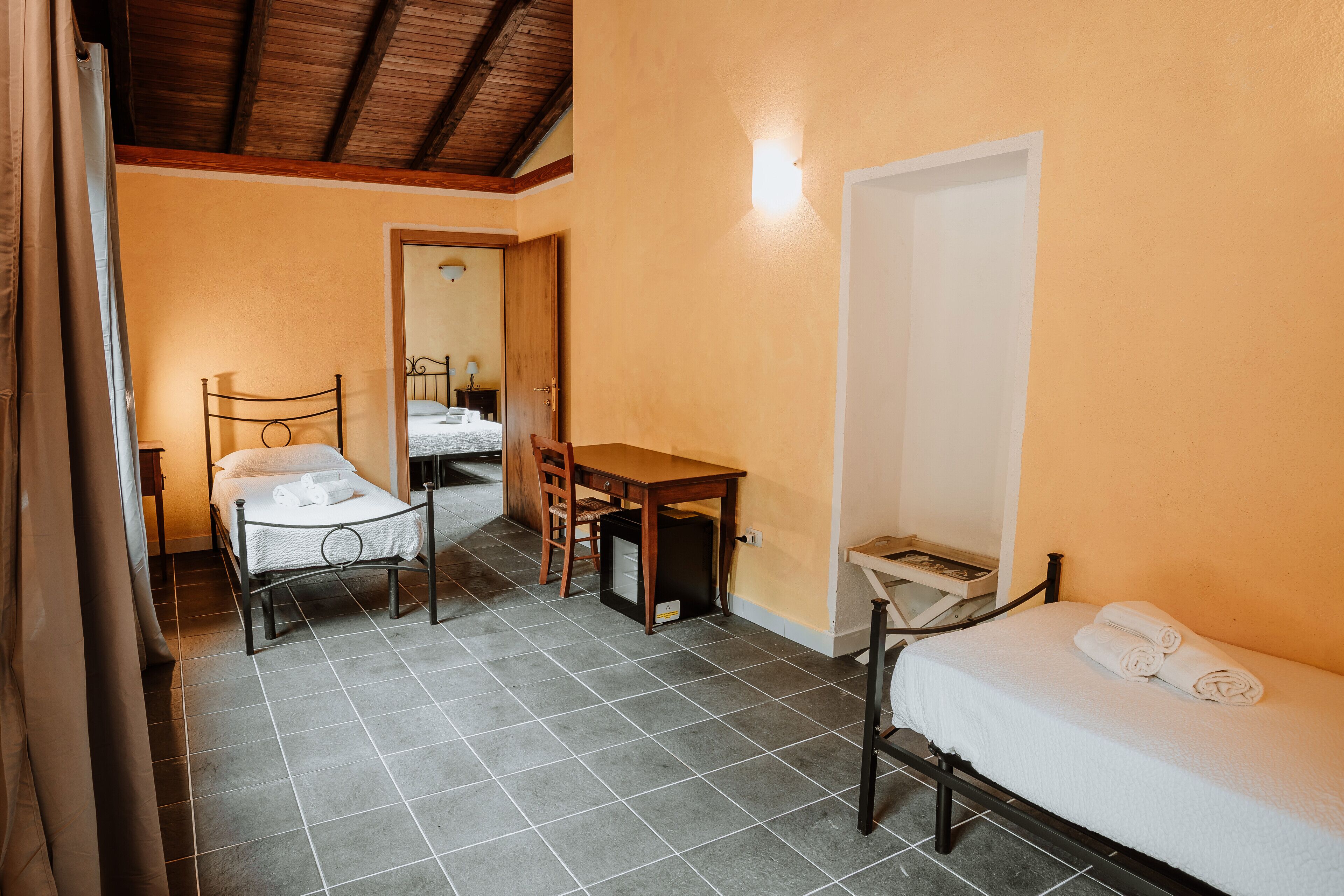 Una habitación de hotel con una cama, un escritorio y una silla.