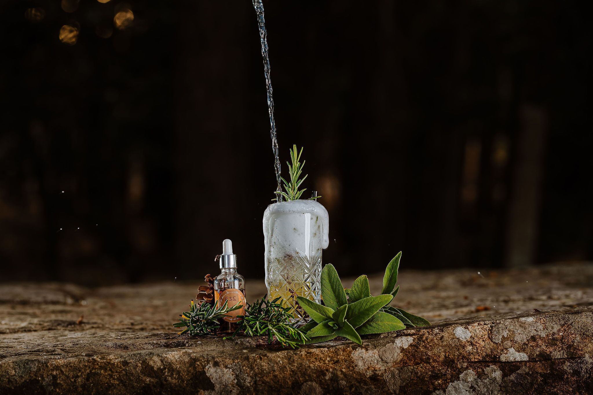 Een glazen fles met een plant erin, geplaatst op een oppervlak met structuur.
