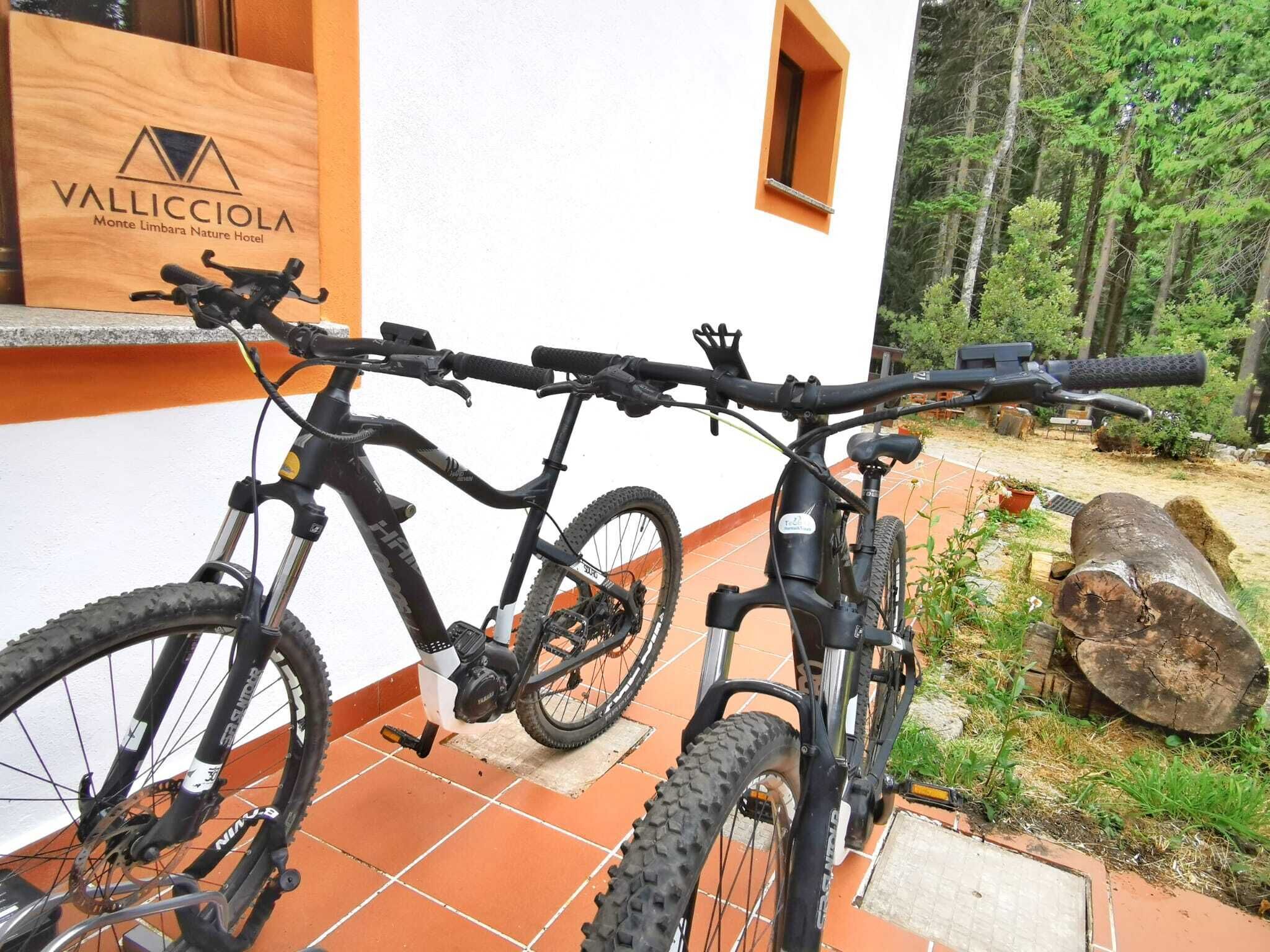 A mountain bike parked outside a building with a sign reading "VALLICCIOLA Monte Limbrana Nature Hotel".