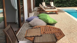 A poolside area with a table and chairs, an umbrella, and a view of the pool. - Olive Grove Villa, private pool & whirl pool, total privacy (Marmaris)