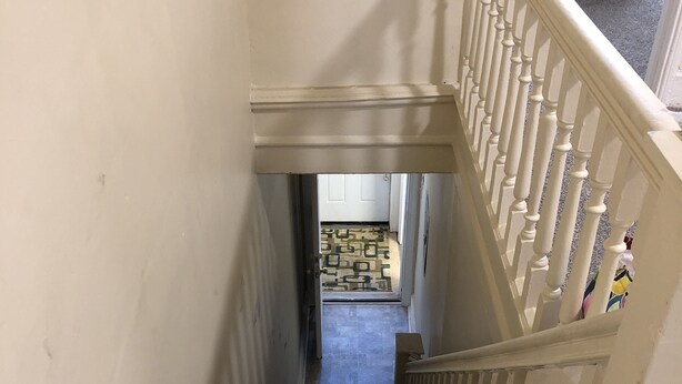 A carpeted staircase with white balusters leading to a landing.