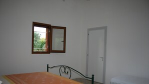 Ein Schlafzimmer mit Bett, Fenster und Tür.