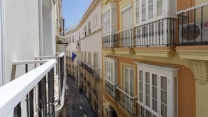 A narrow street with buildings featuring balconies and large windows. - COLON15 Family Home by Cadiz4Rentals (Cádiz)