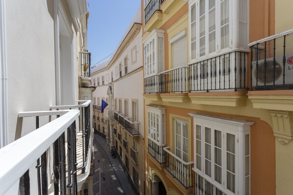 A narrow street with buildings featuring balconies and large windows. - COLON15 Family Home by Cadiz4Rentals (Cádiz)