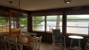 Un chalet confortable avec un coin repas, un fauteuil à bascule et une vue sur un lac.