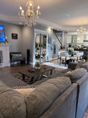 A modern living room with a sofa, coffee table, and a TV. - Why stay anywhere else!  (St. Catharines)