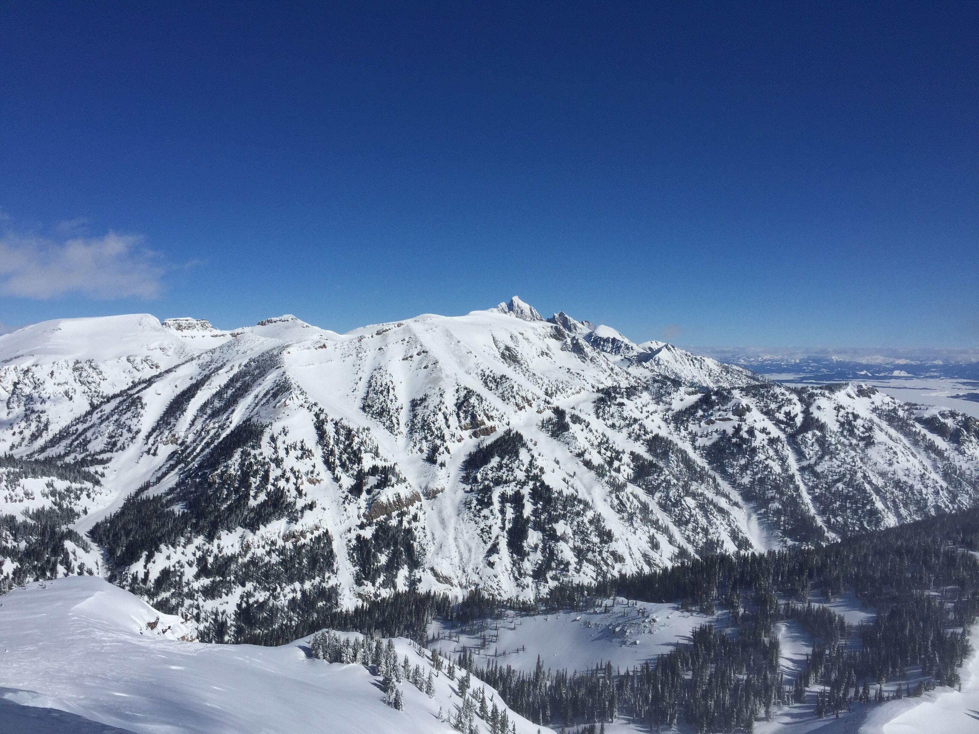 Une chaîne de montagnes enneigée sous un ciel dégagé.
