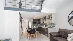Um apartamento moderno com área de refeições, cozinha e sala de estar.