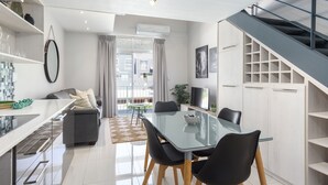 Uma cozinha moderna com área de jantar, escada e vista para o exterior.