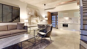 Ein modernes Wohnzimmer mit einer Couch, einem Couchtisch und einem Essbereich mit Stuhl und Tisch.