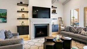 Una sala de estar moderna con chimenea, televisor montado y sofá.