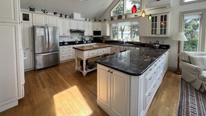 Una cocina amplia con armarios blancos, una isla grande y un tragaluz.