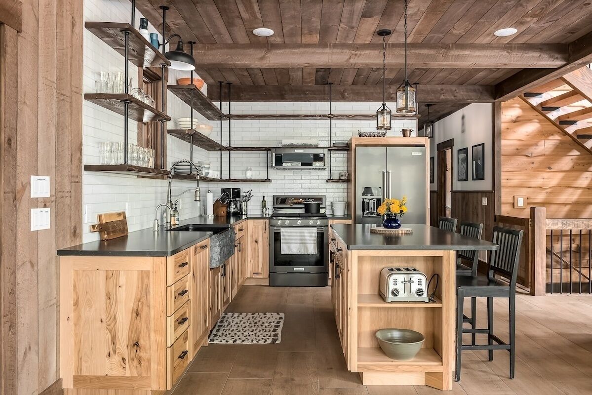 A modern kitchen with wooden cabinetry, a central island, and a dining area with a table and chairs.