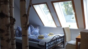 Una camera da letto con un letto, una sedia e una finestra.
