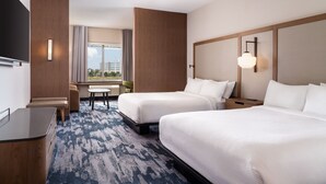 A hotel room with two beds, a desk, a TV, and a window with a view of buildings. - Fairfield Inn & Suites by Marriott Cleveland Tiedeman Road (Brooklyn)