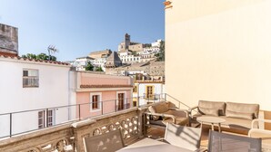 A balcony with outdoor furniture, a view of a hillside town, and a building with a balcony railing. - New duplex in Ibiza center with Dalt Vila views (Ibiza)